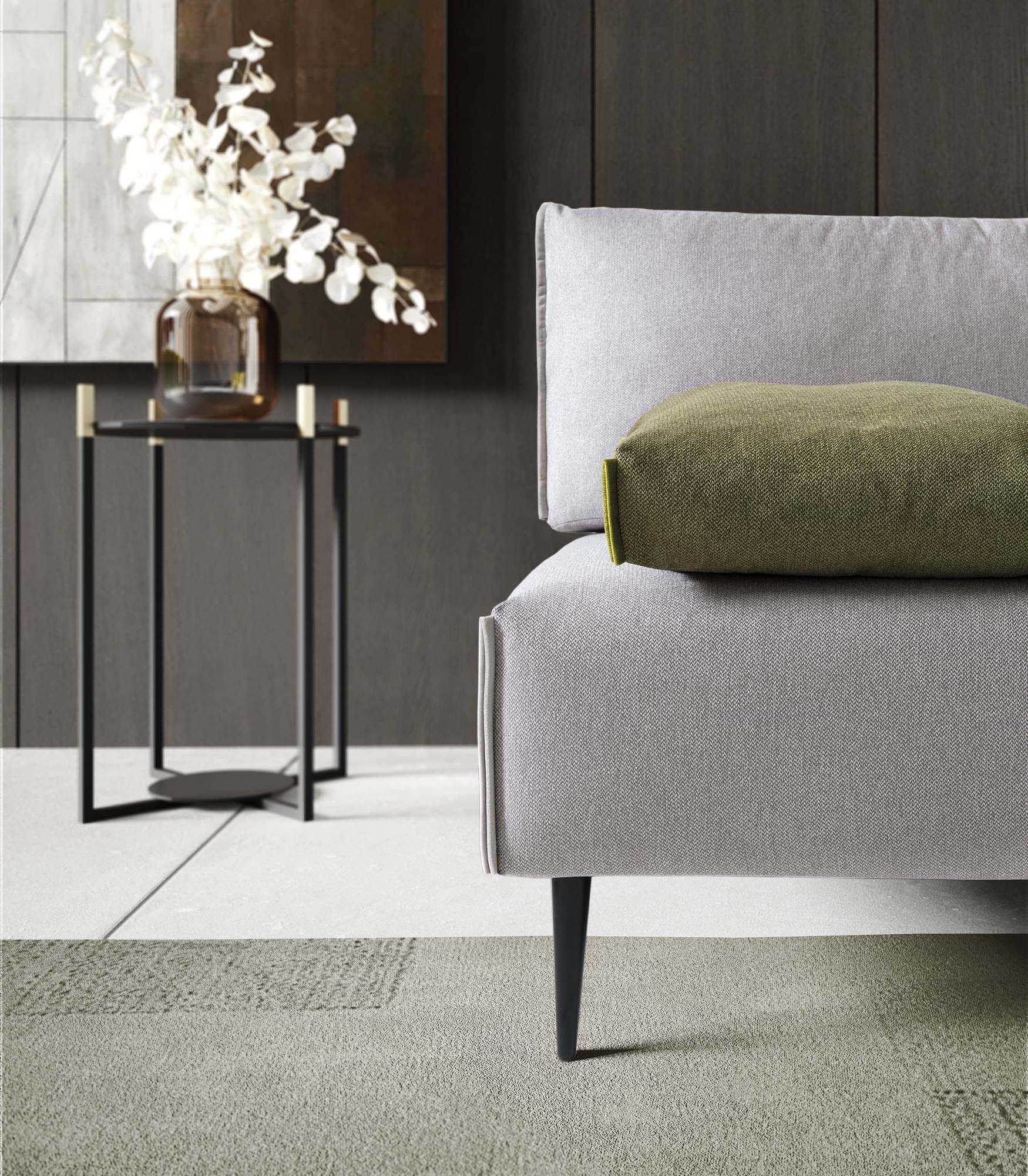 Dettaglio della seduta di un divano di design con piedini alti e sottili