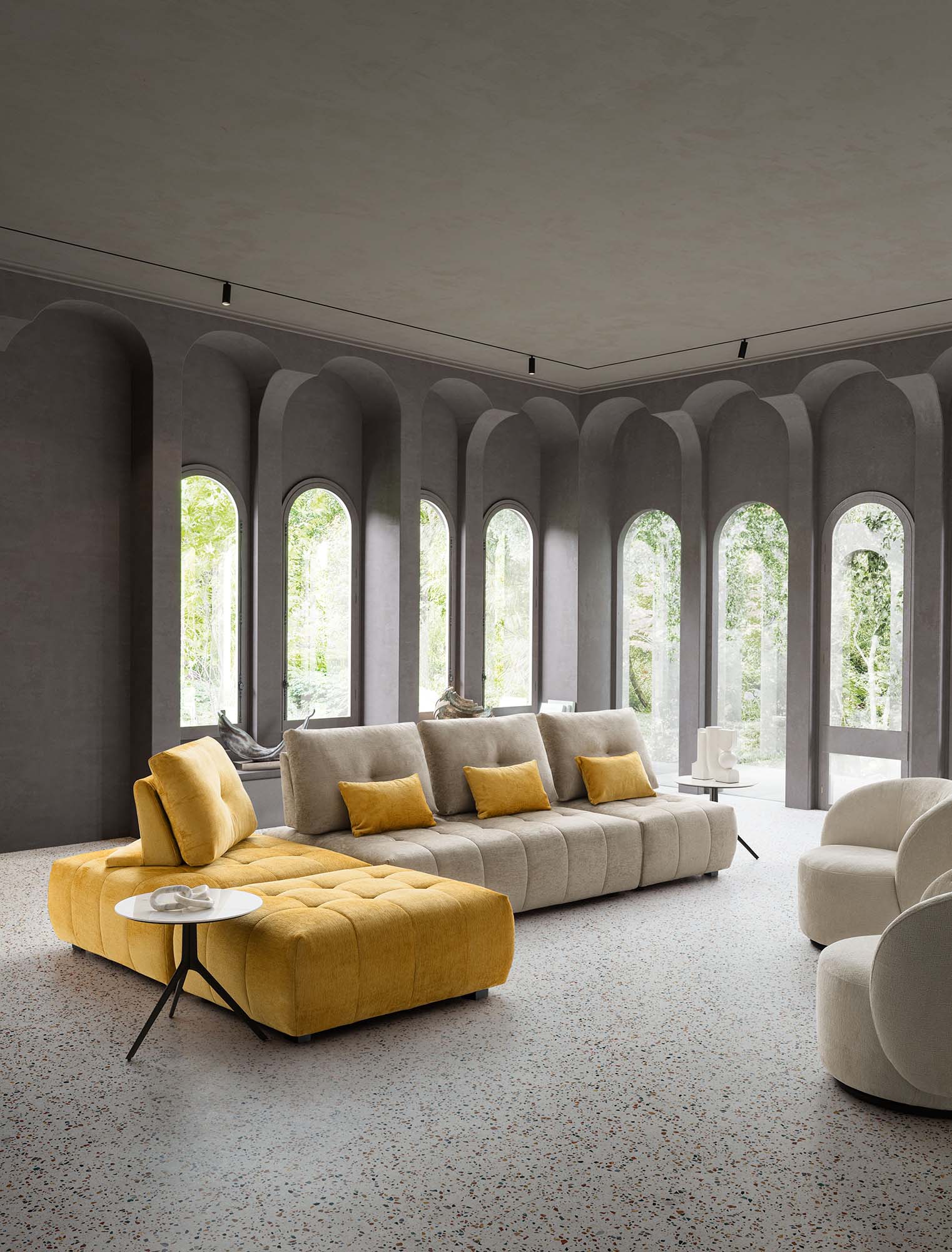 Divano modulare disposto ad angolo con schienali traslabili alti e piedini bassi. Seduta trapuntata e di design.