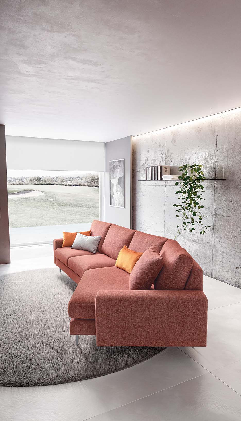 Visione laterale di un divano con seduta asimmetrica. Stile moderno con braccioli squadrati e semplici.