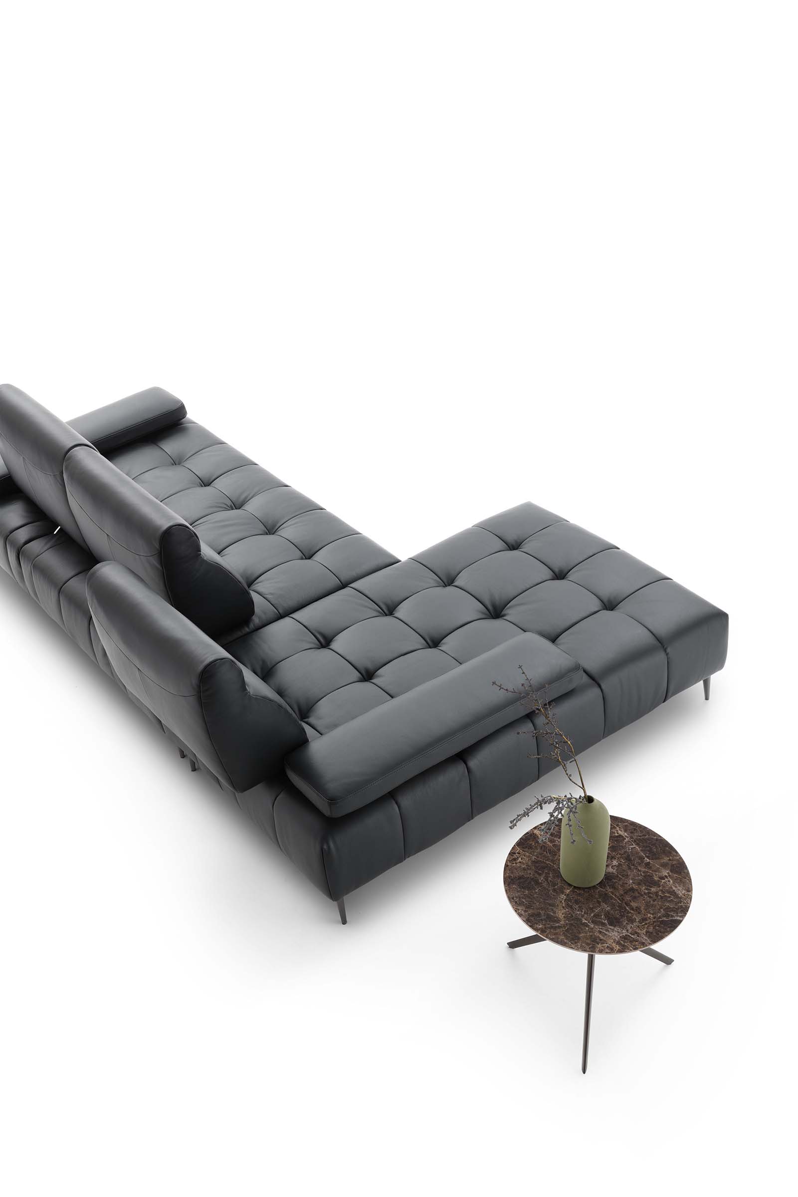 Divano modulare in pelle e trapuntato composto a chaise longue. Schienale traslabile per modificare l'ampiezza di seduta.
