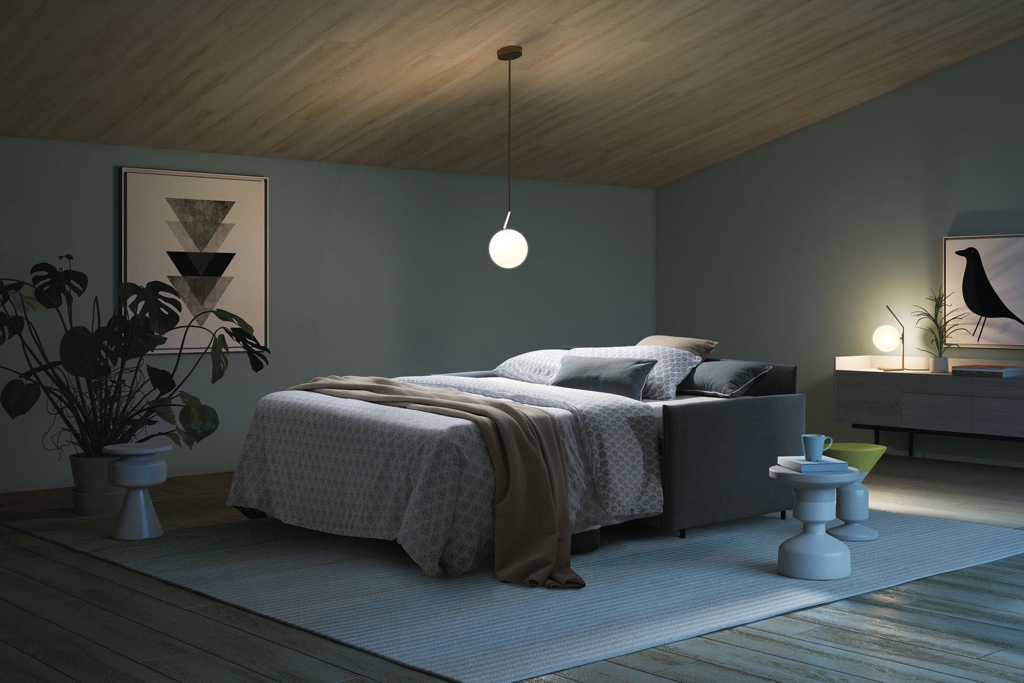 Divano Naxos aperto in modalità letto matrimoniale comodo con coperte e guanciali in un piano mansardato