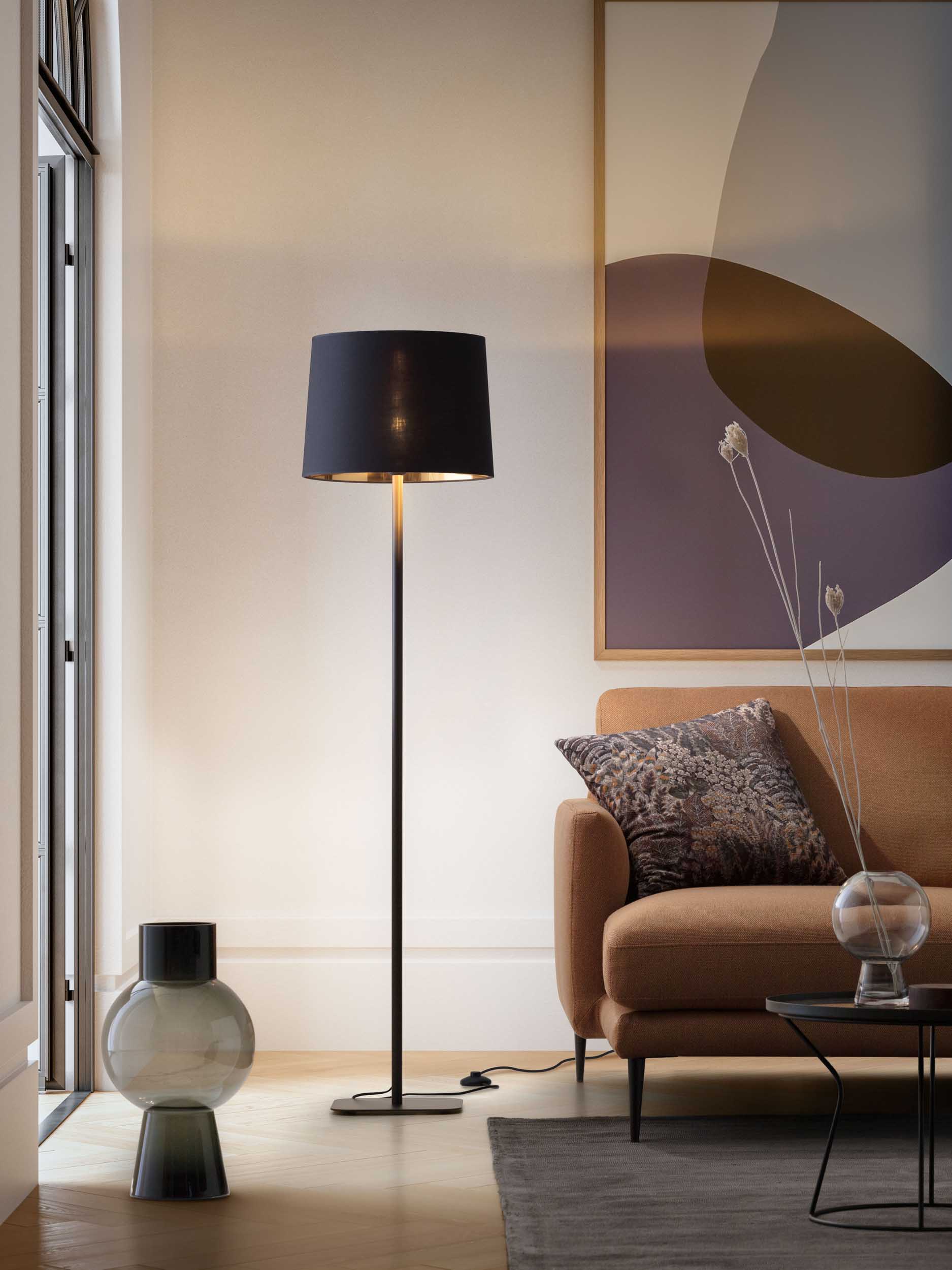 Lampada da terra con paralume nero in un salotto moderno colorato