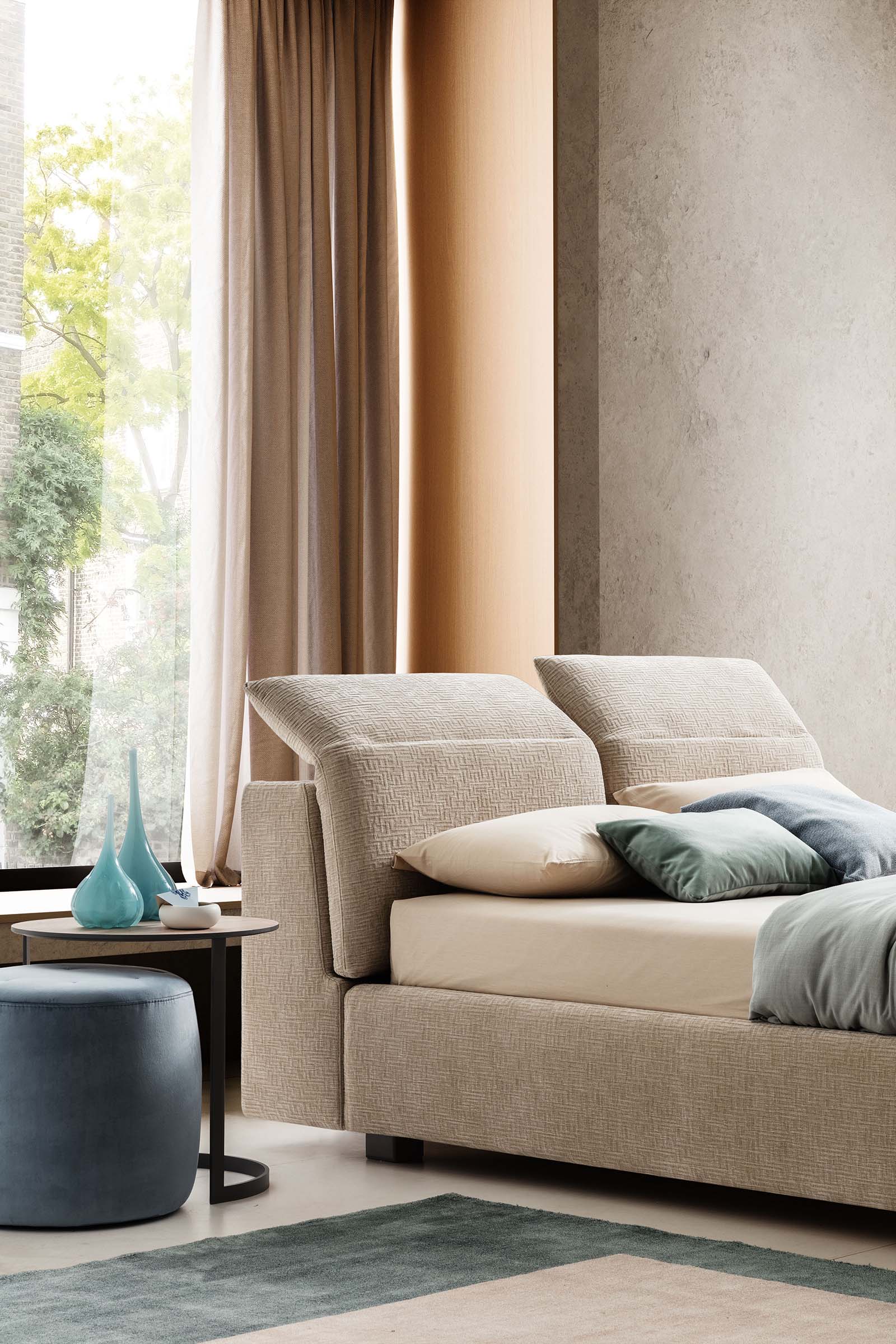 Letto matrimoniale moderno con poggiatesta regolabili aperti in una camera ampia moderna
