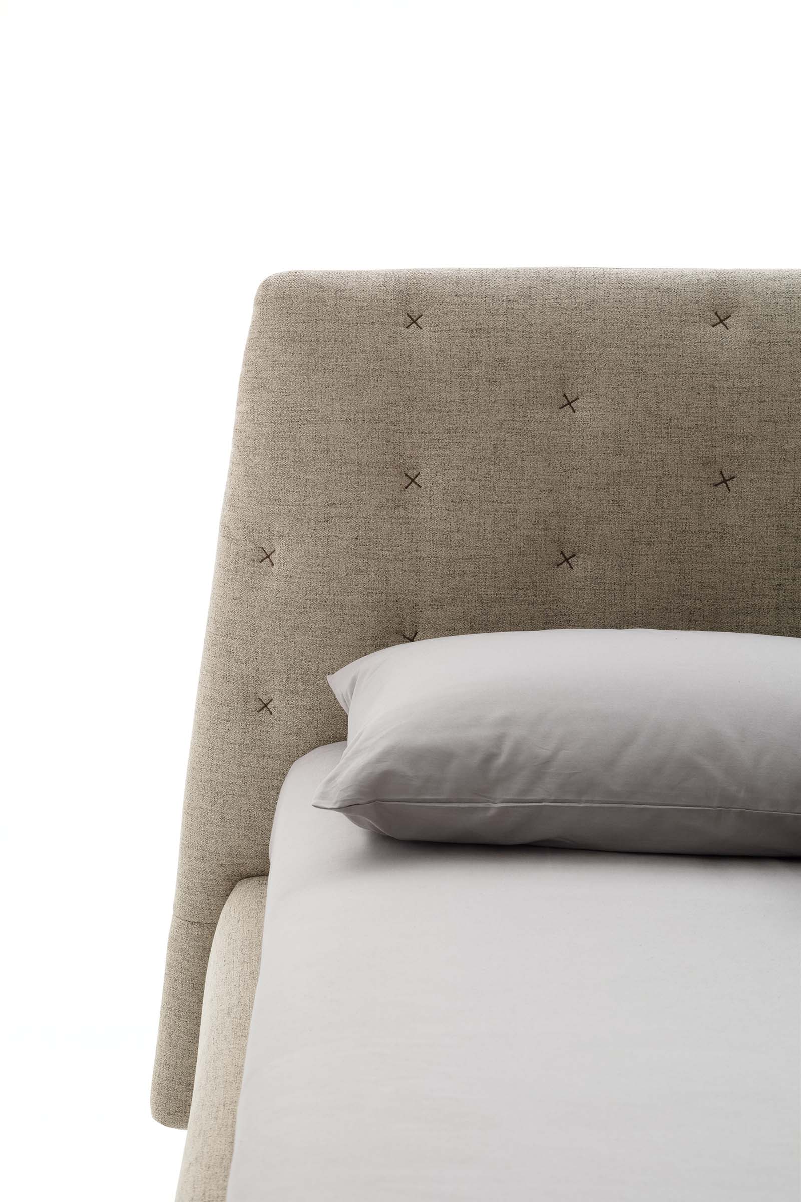 Testiera di un letto simil-capitonné con cuciture incrociate
