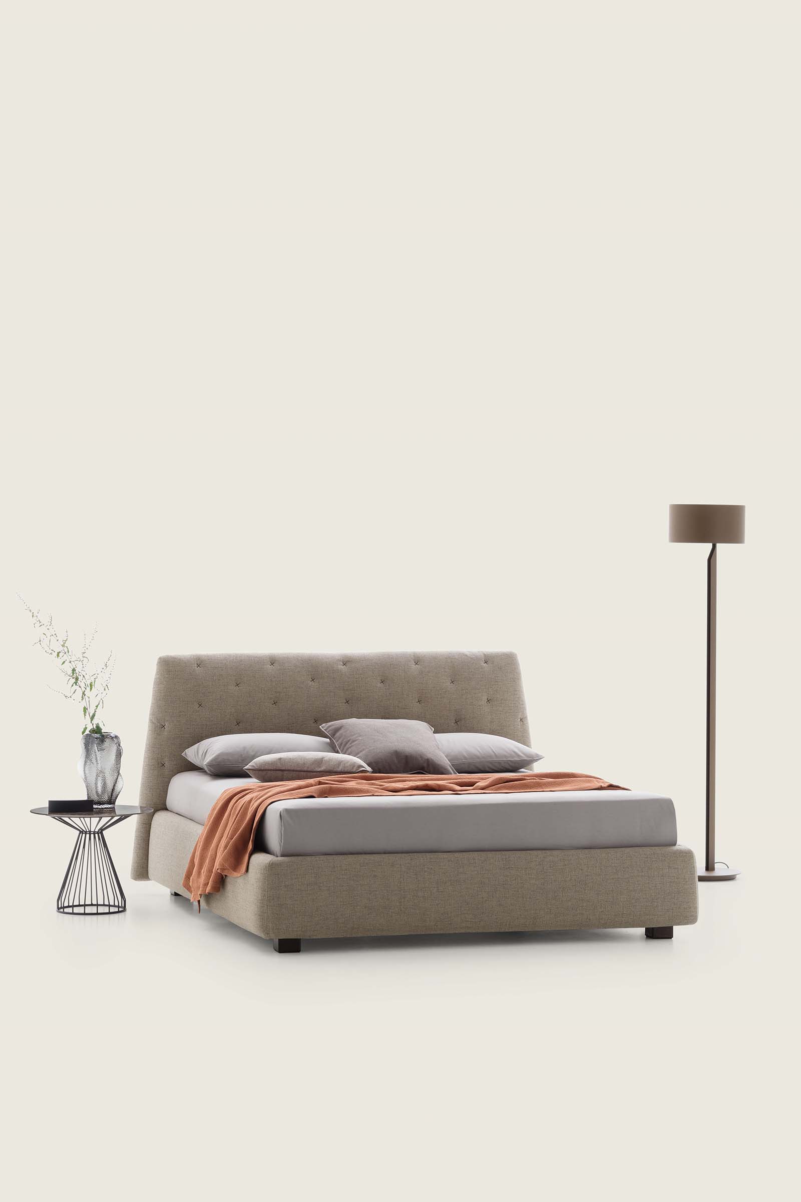 Letto color panna con piedini bassi e giroletto largo. Testiera trapuntata.