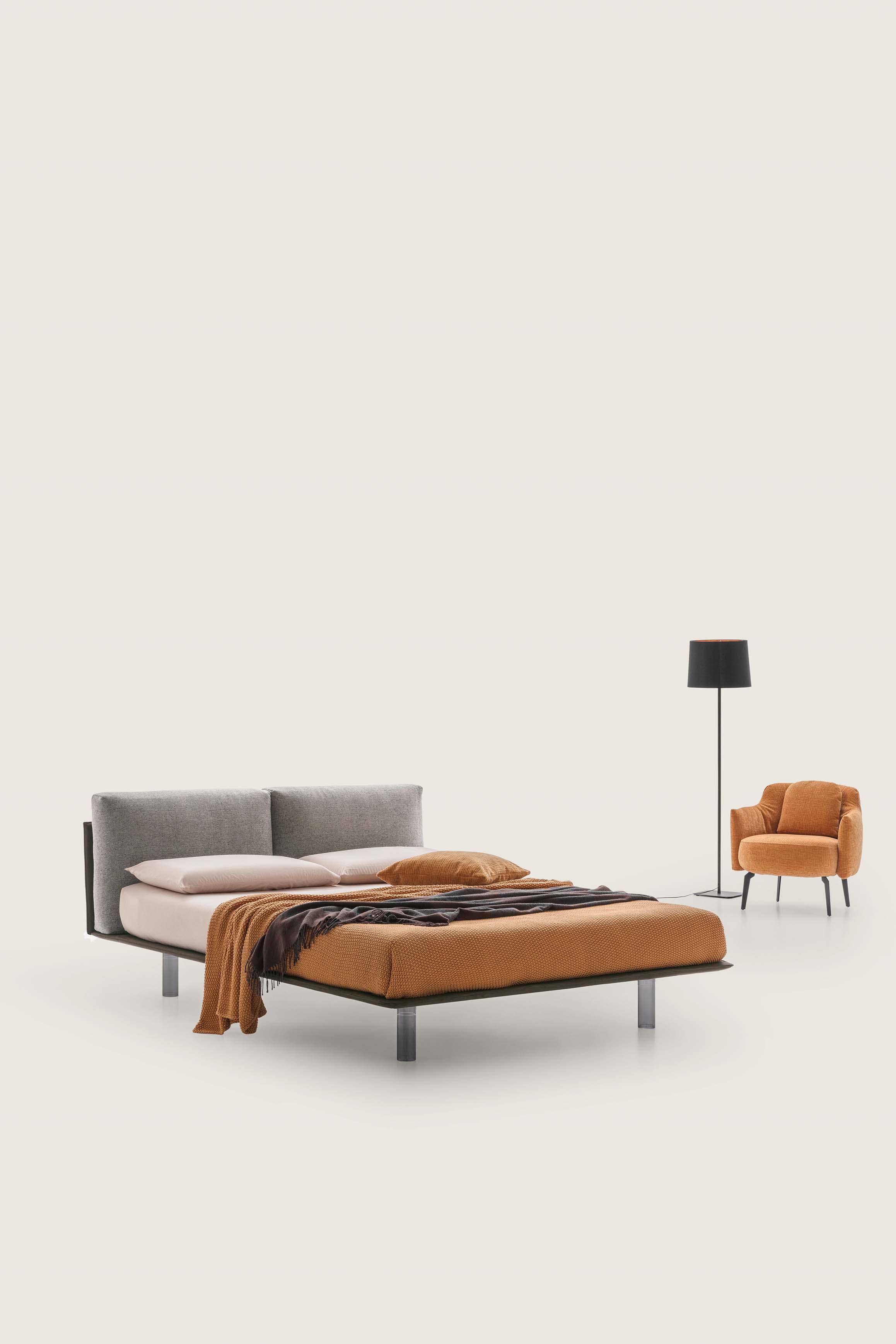 Letto con giroletto sottilissimo color grigio scuro e testiera con cuscini imbottiti color tortora