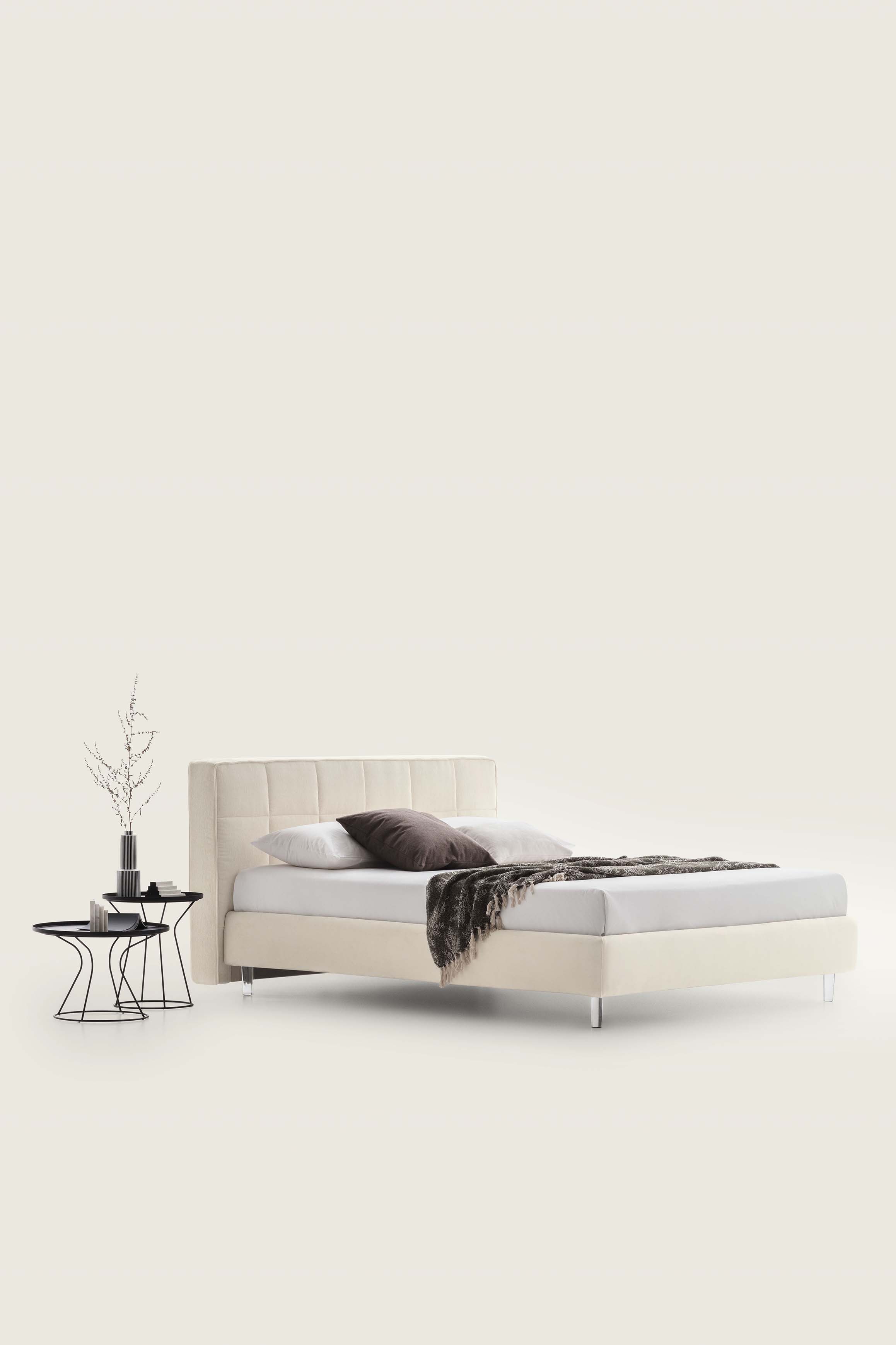 Letto matrimoniale color bianco panna con motivo a riquadri e piedini trasparenti