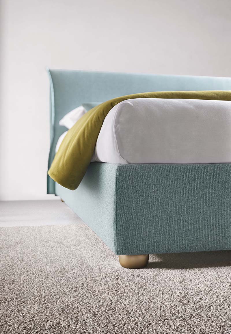 Dettaglio dei piedini bassi di un letto colore azzurro