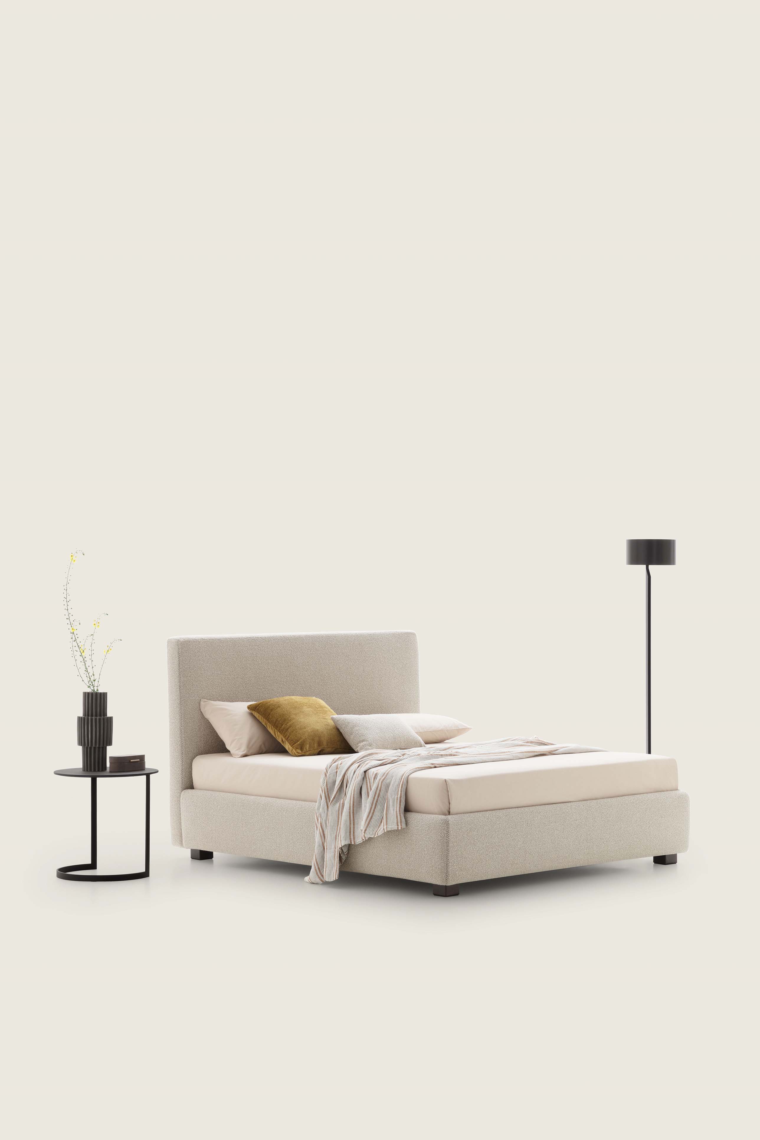 Letto color bianco crema con tramature evidenti abbinato a tavolini e lampade moderne