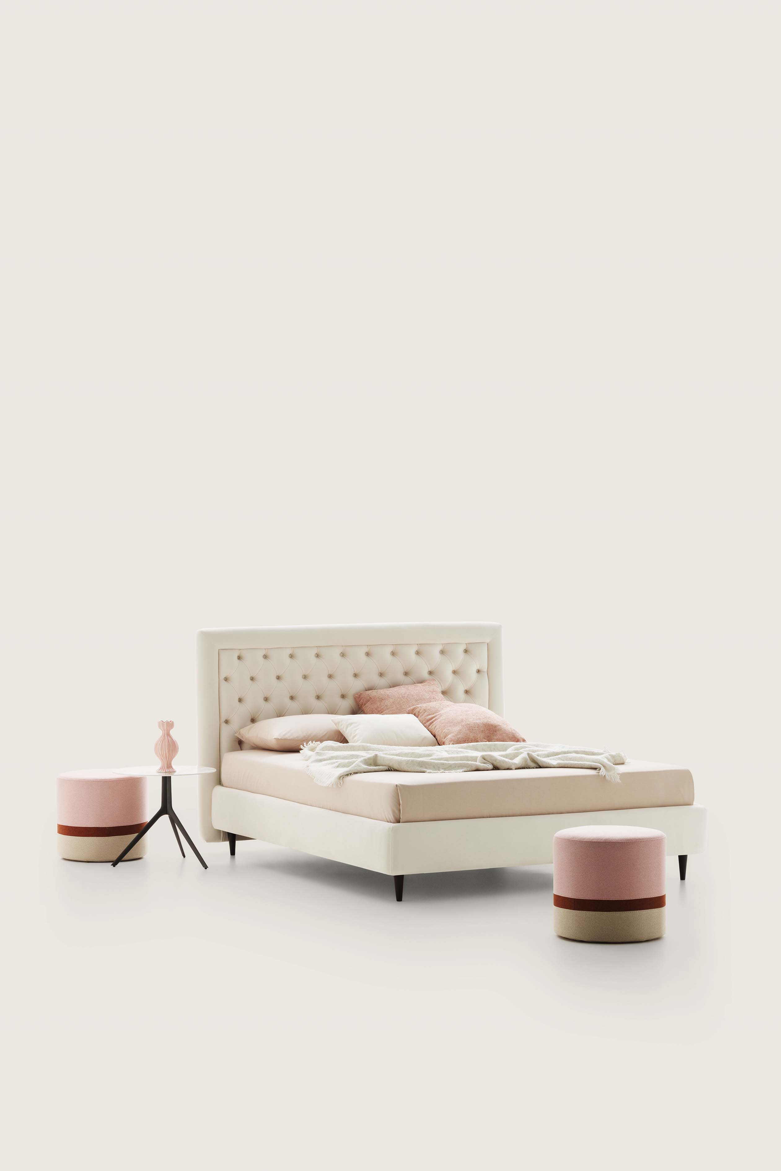 Letto matrimoniale con capitonné rivestito in tessuto color crema e pouf abbinati
