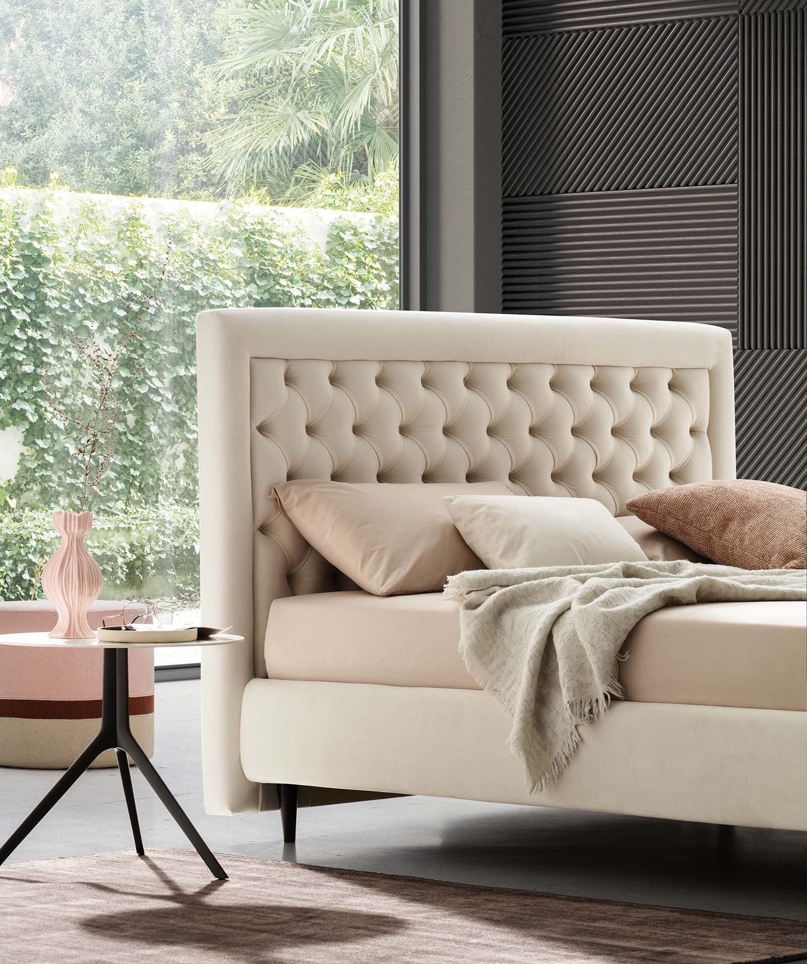 Letto matrimoniale stile chesterfield con testiera capitonné color crema in un ambiente moderno