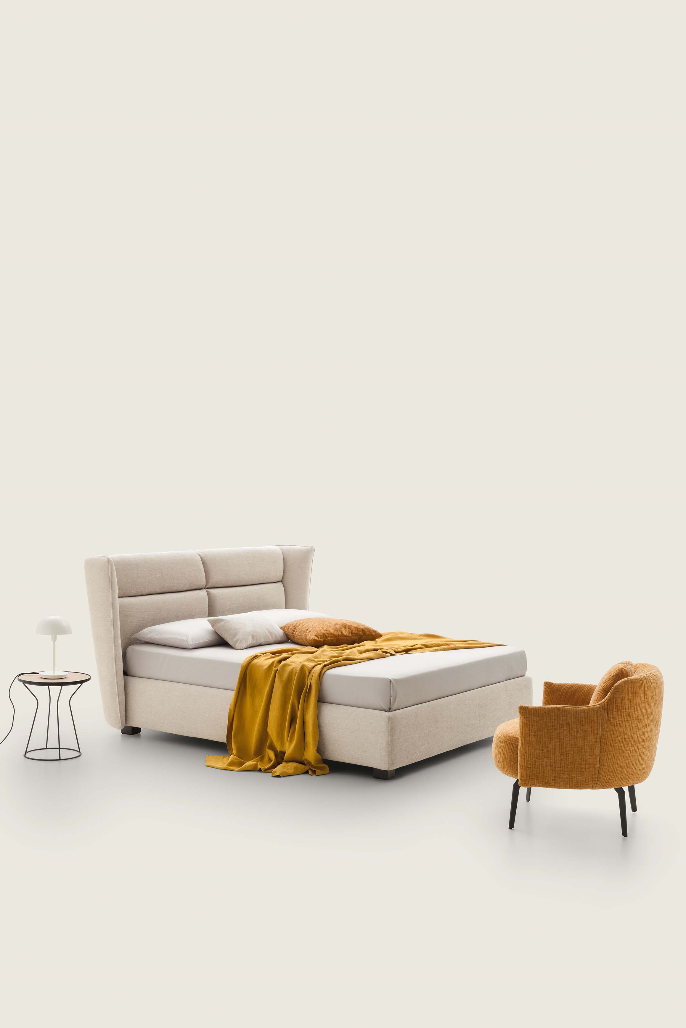 Letto matrimoniale color crema con piedini bassi e testiera alta con trapuntature