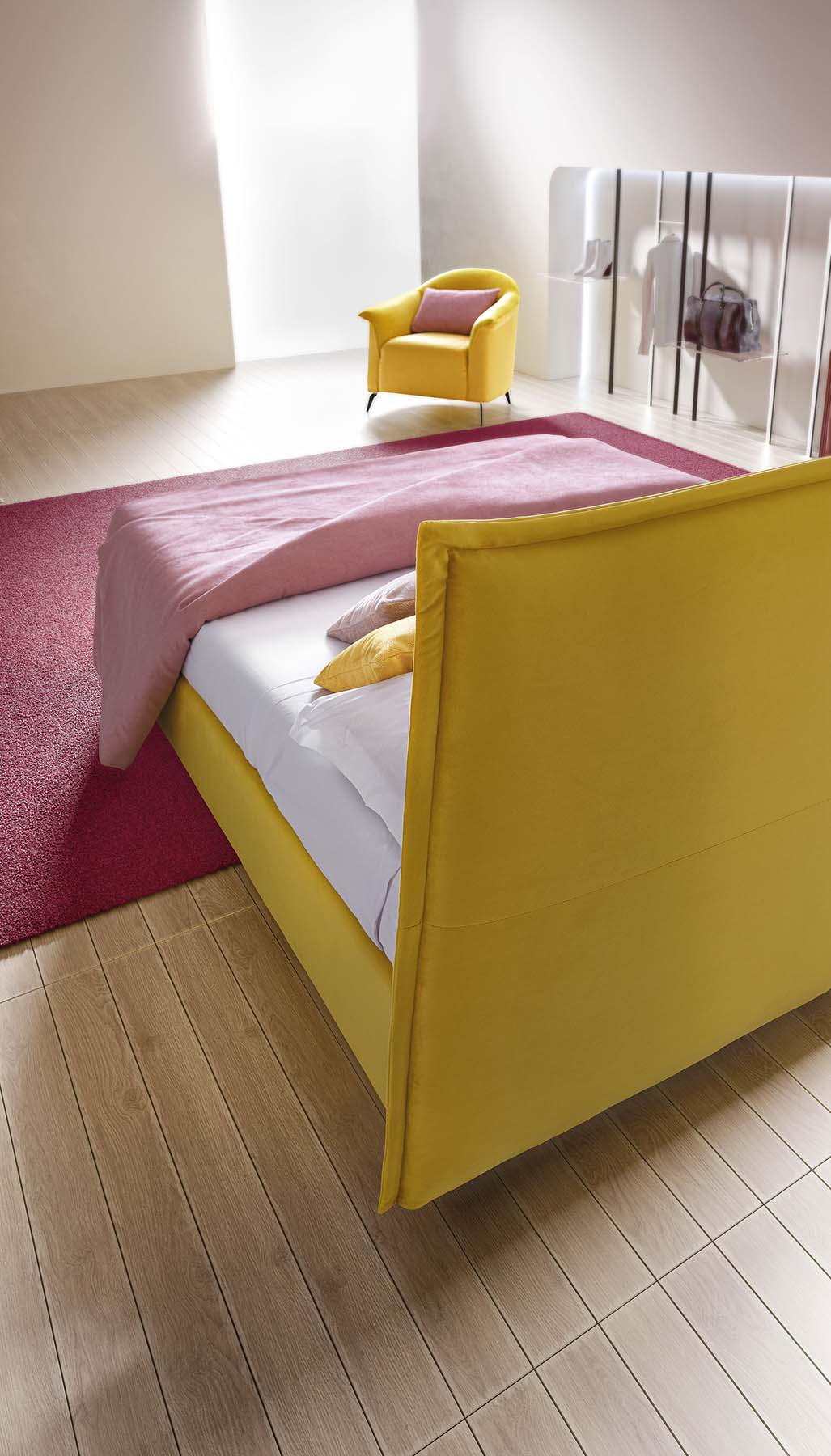 Dettaglio della testiera di un letto in tessuto giallo visto dal retro