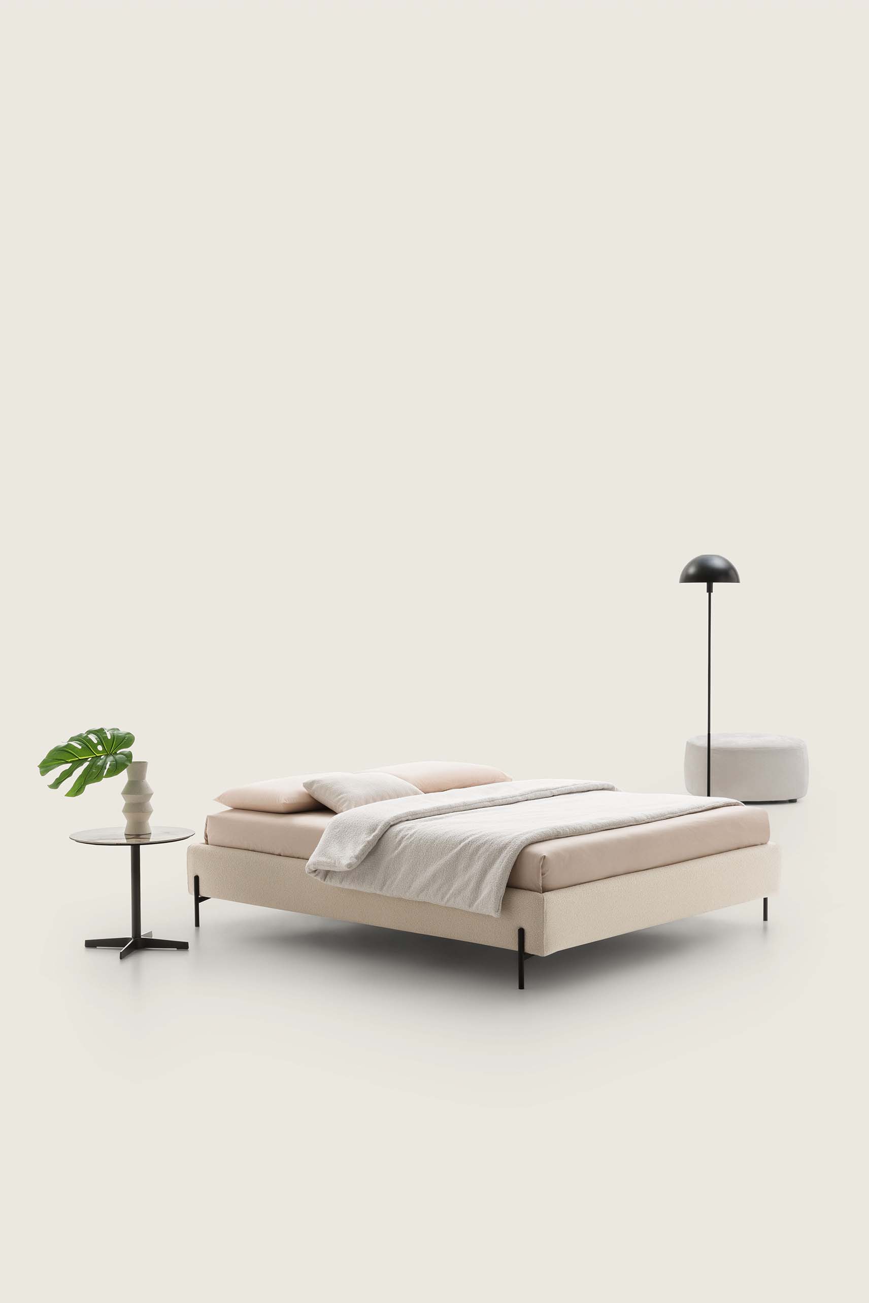 Letto matrimoniale senza testiera colore crema abbinato a pouf e tavolini