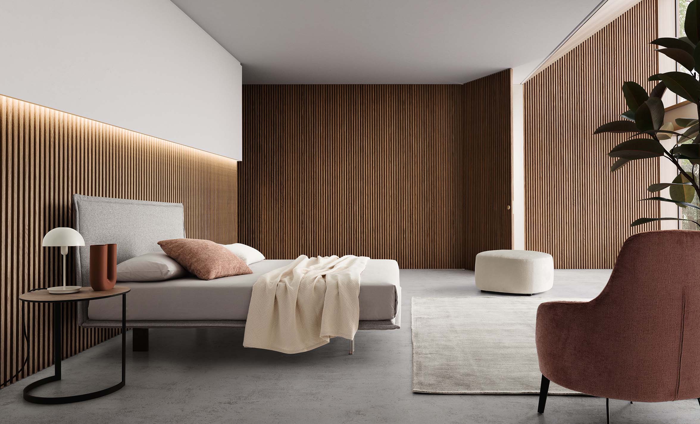 Stanza moderna arredata con letto salvaspazio abbinato a pouf e tavolino