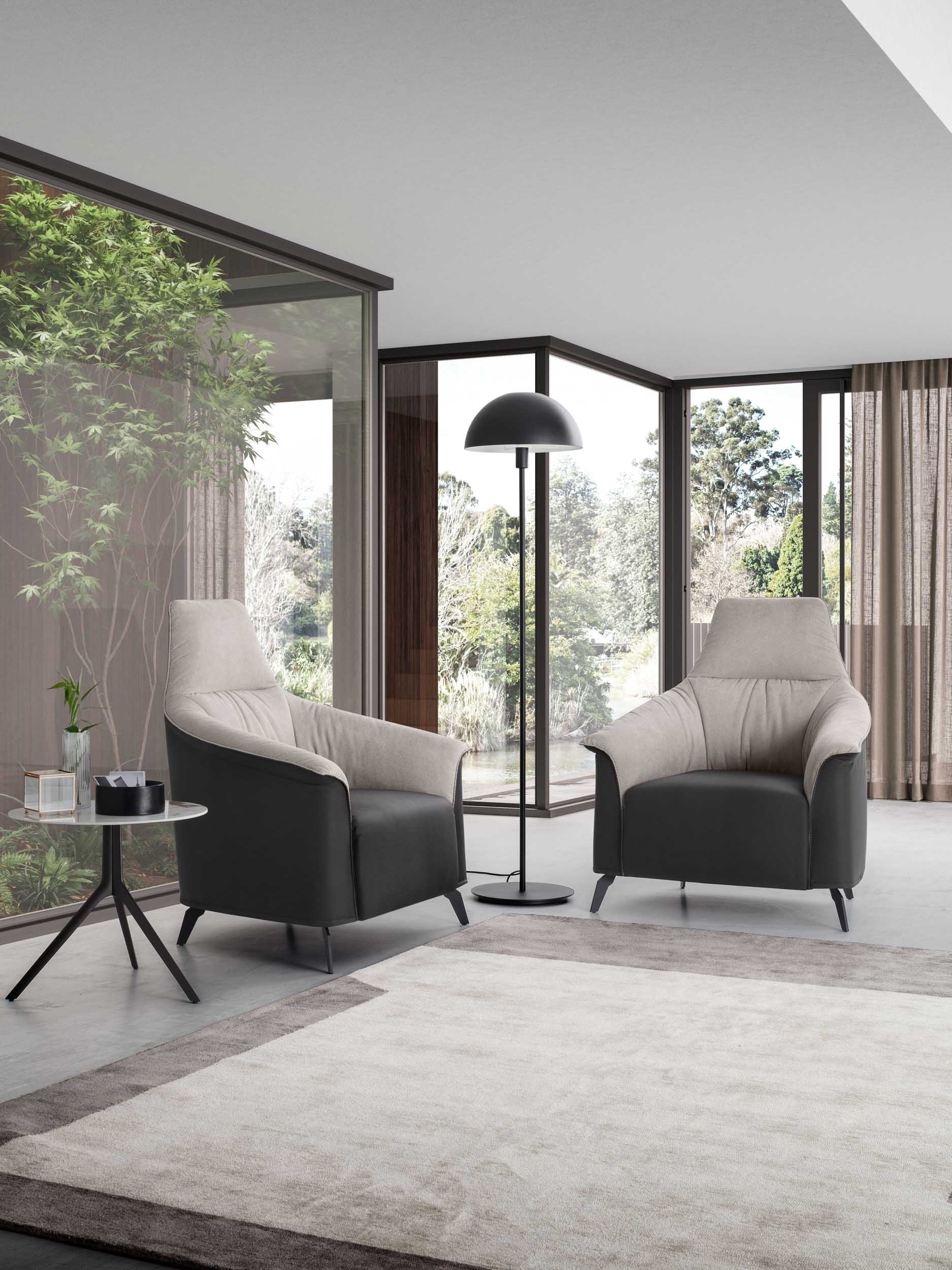 Angolo relax moderno con poltroncine in pelle bianche e nere con schienale alto