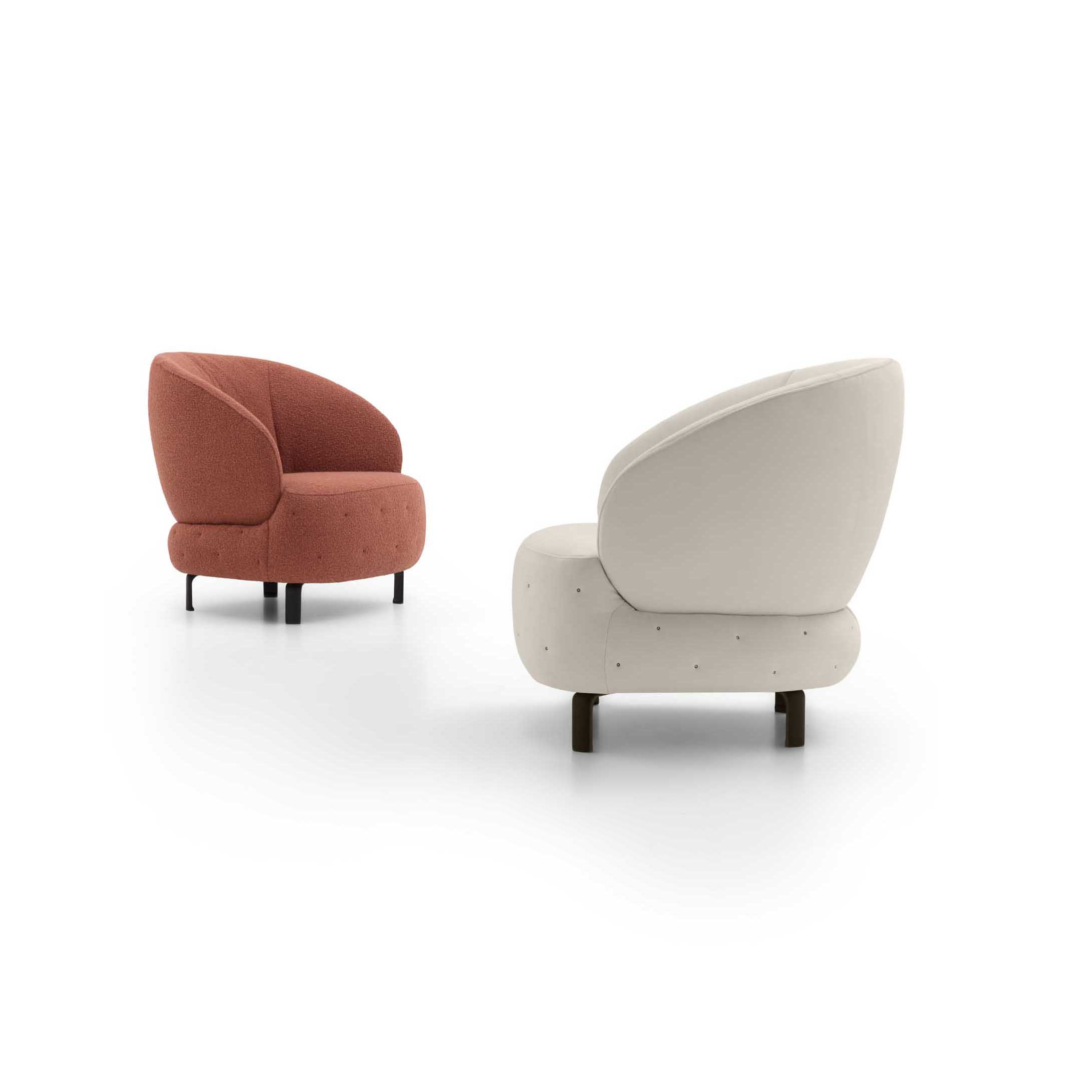 Poltroncina tondeggiante in due versioni: bianca e color rame con trapuntatura