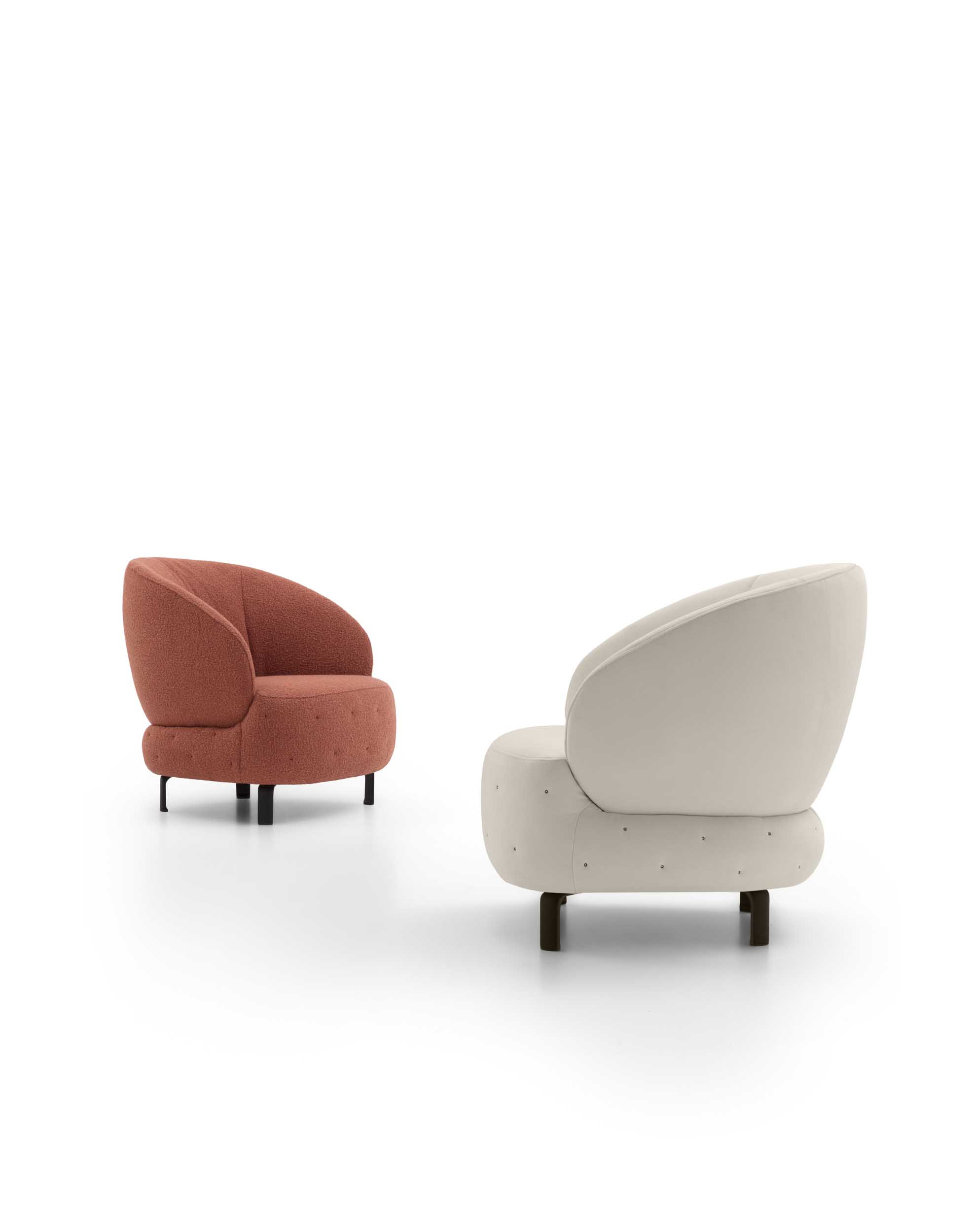 Poltroncina tondeggiante in due versioni: bianca e color rame con trapuntatura
