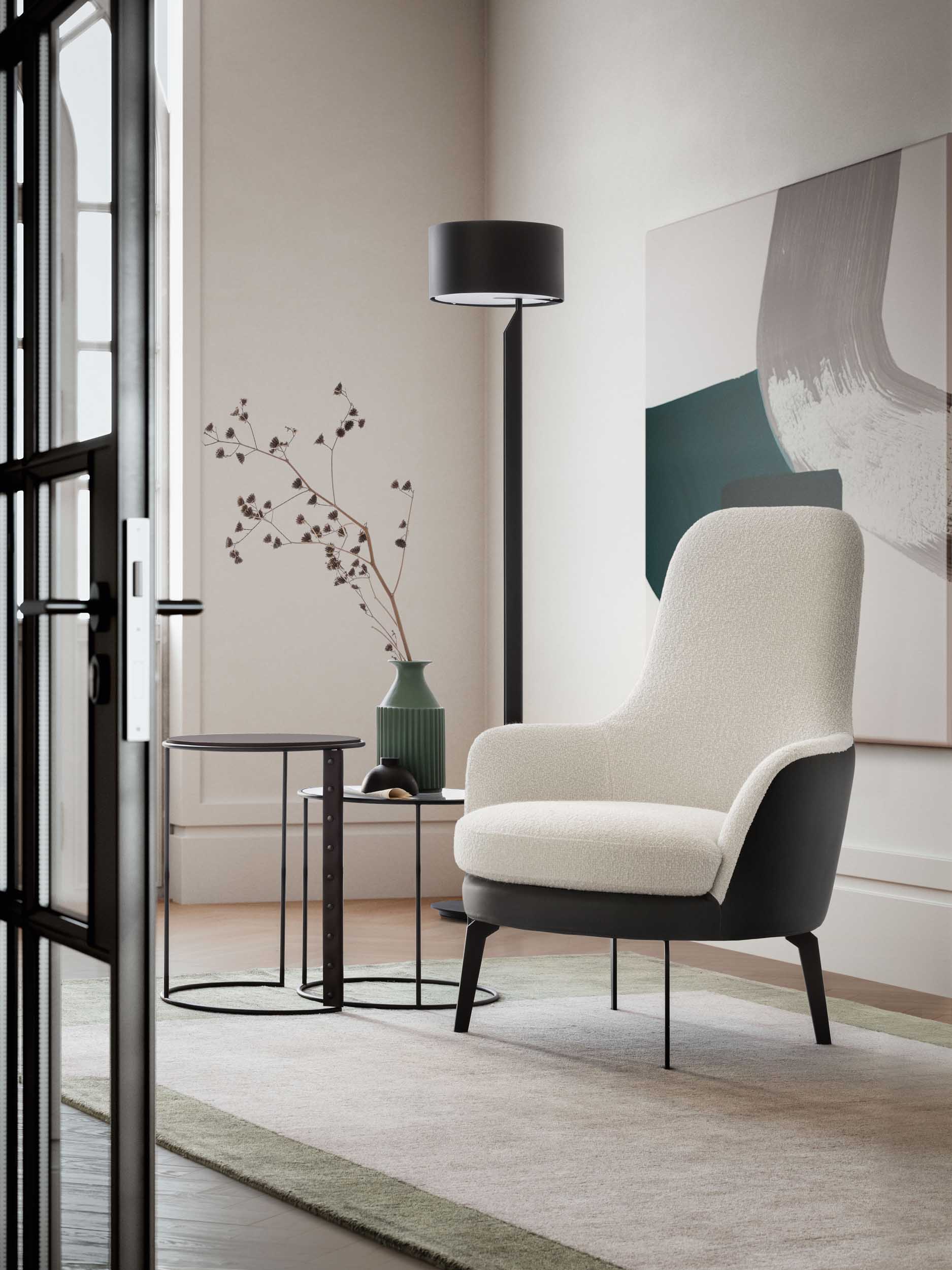 Poltroncina bianca con fianchi neri in un salottino moderno